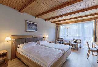 Doppelzimmer Standard im Sunstar Hotel Grindelwald mit Holztäfer-Decke, Sitzecke am Fenster und Schreibtisch