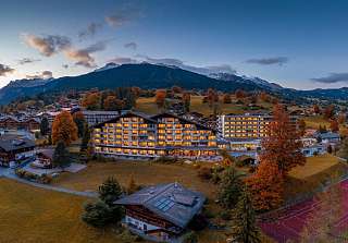 Aussenansicht des Sunstar Hotels in Grindelwald mit Blick auf die imposante Berglandschaft und herbstliche Wiesen