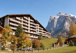Aussenansicht des Sunstar Hotels in Grindelwald mit Blick auf die imposante Berglandschaft und herbstliche Wiesen