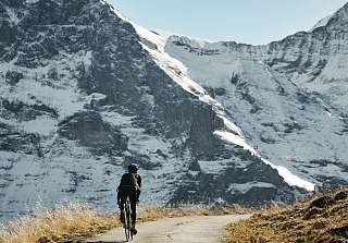 Drei Mountainbiker auf einem Singletrack oberhalb von Grindelwald mit beeindruckendem Blick auf die Eigernordwand und das Berner Alpenpanorama – Sunstar Hotel Grindelwald.