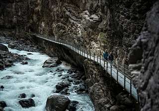 Une personne marche sur une passerelle à travers les gorges étroites du glacier à Grindelwald. © Schweiz Tourismus