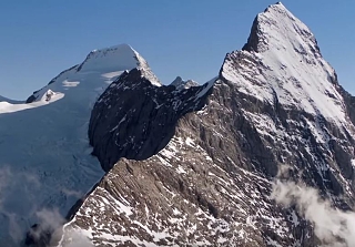 Aerial view of the imposing Eiger north face and the Mönch with snow-covered peaks and clouds – the iconic alpine panorama around Grindelwald at Sunstar Hotel.