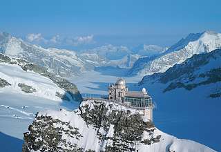 L'Observatoire du Sphinx sur le Jungfraujoch se dresse sur un rocher au-dessus du glacier d'Aletsch, entouré de sommets alpins enneigés sous un ciel bleu.