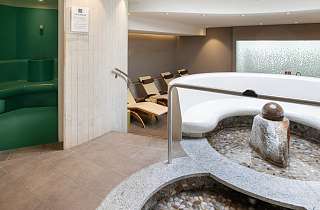 Wellnessbereich im Sunstar Hotel Grindelwald mit rundem Kneipp-Tretbecken, Ruheliegen und Dampfbad