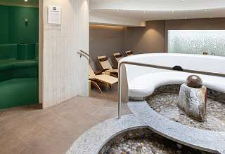 Wellnessbereich im Sunstar Hotel Grindelwald mit rundem Kneipp-Tretbecken, Ruheliegen und Dampfbad