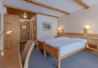 Chambre double Standard rustique avec lit et bureau sous un plafond à poutres en bois