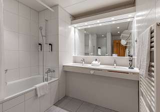Salle de bains de la Chambre familiale Eiger au Sunstar Grindelwald avec double vasque et baignoire