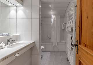 Salle de bains de la Suite Wetterhorn au Sunstar Grindelwald avec baignoire et lavabo