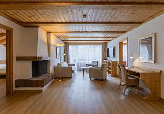 Espace salon de la Suite Wetterhorn au Sunstar Grindelwald avec cheminée et coin salon